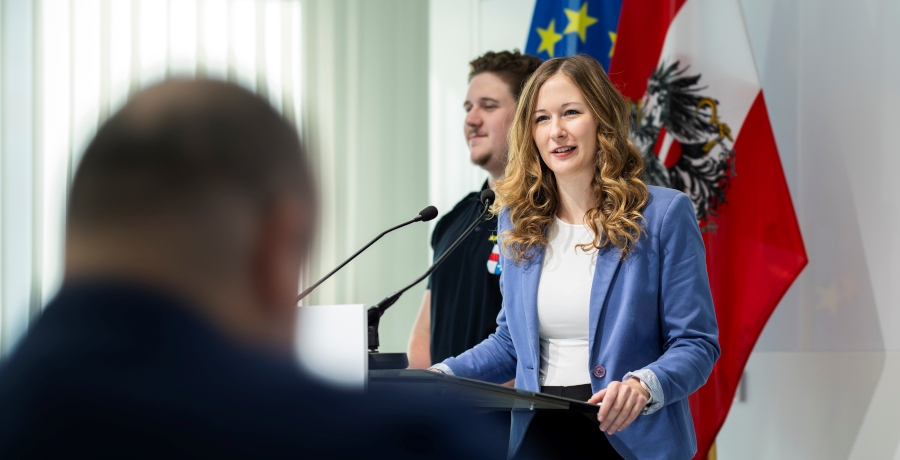 Staatssekretärin Claudia Plakolm steht bei einer Pressekonferenz vor dem Rednerpult