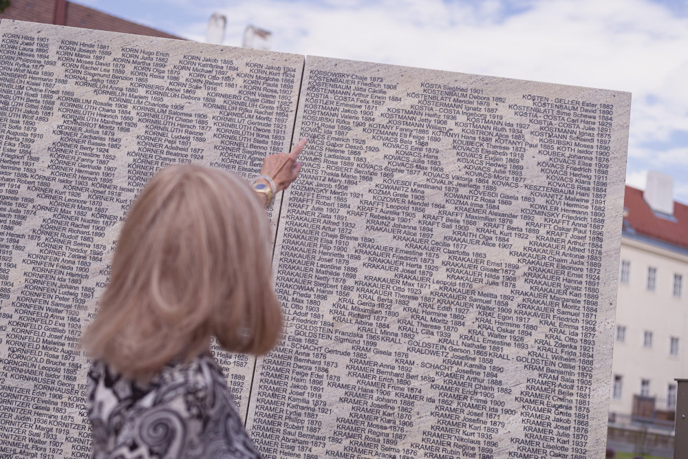 Vera Chapman zeigt auf einen Namen auf einer Mauer der Shoa Namensmauern Gedenkstätte
